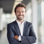 portrait of successful senior businessman consultant looking at camera and smiling inside modern office building